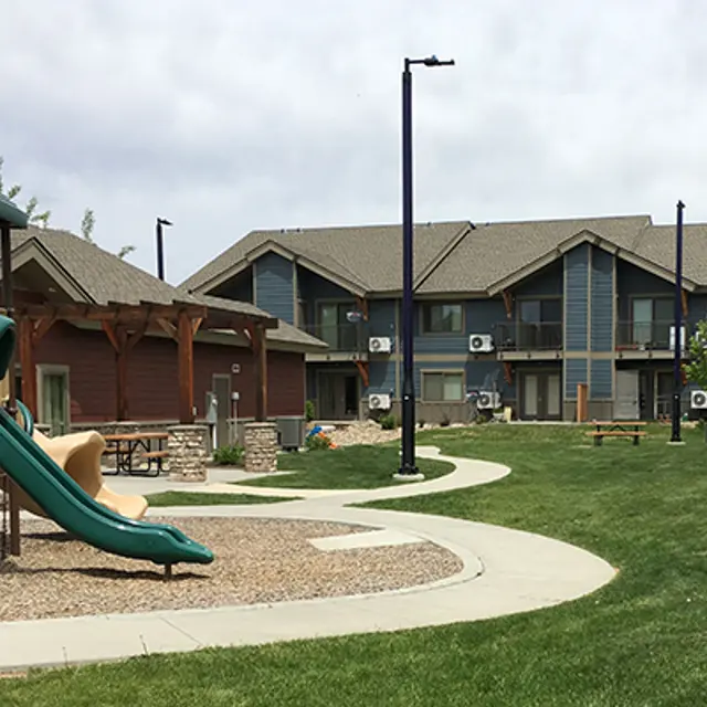 Playground and Apartment Complex View of a playground area with a slide and nearby apartment buildings.