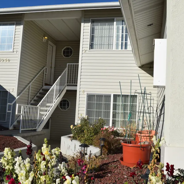 Apartment Building Exterior View Exterior view of an apartment building with a staircase and potted plants.