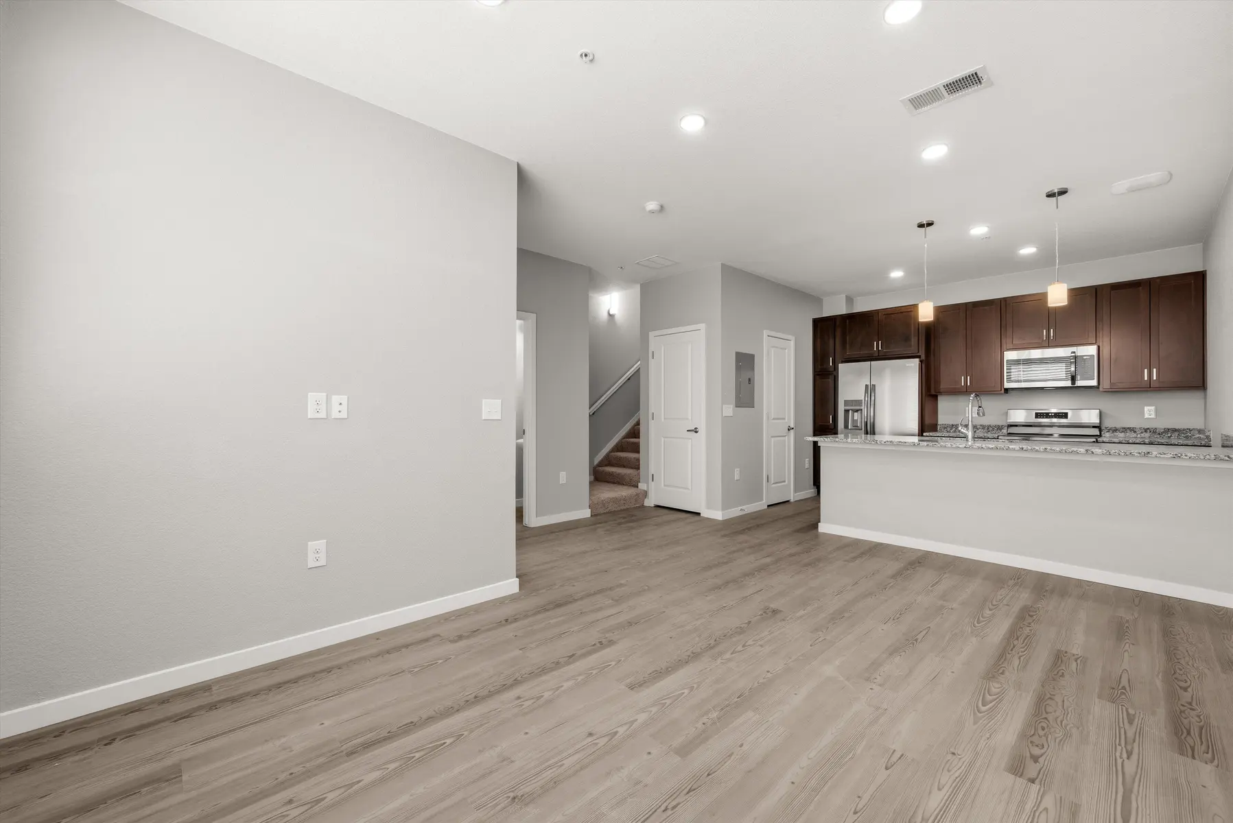 Modern Apartment Interior Interior view of a modern, open-concept apartment showing a living area and kitchen with wooden floors and gray walls.