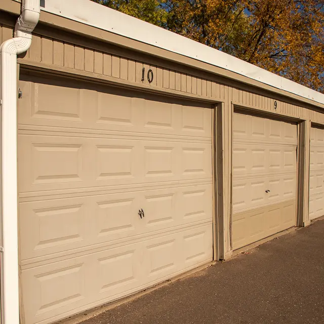 Row of beige storage units with closed doors, displaying numbers 10 and 9, and surrounded by autumn trees.