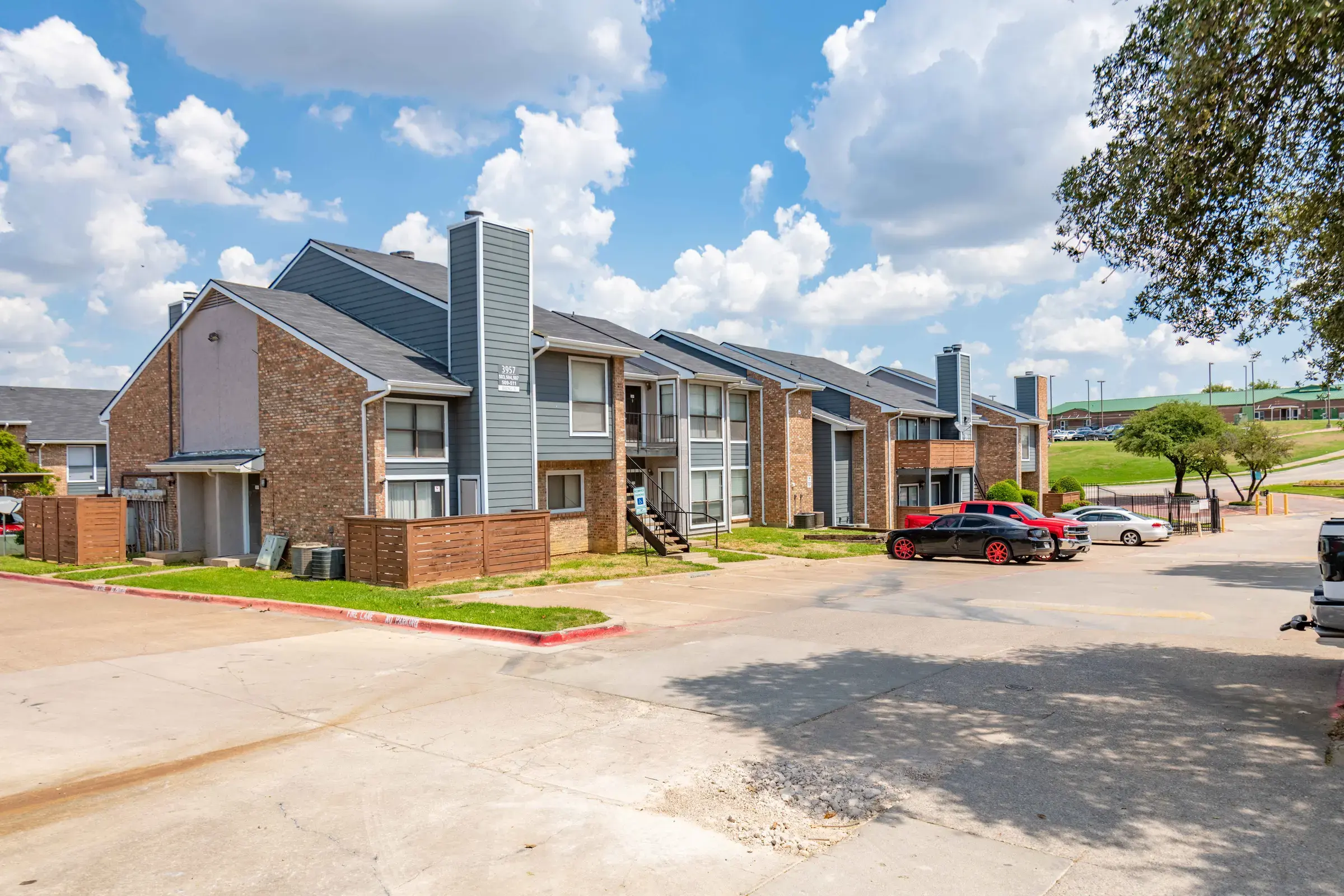 View of apartment buildings under a blue sky with clouds.