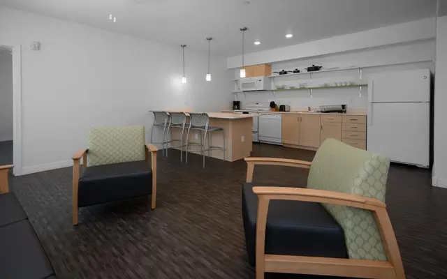 Modern Living Space A modern living area featuring two comfortable armchairs and a kitchen in the background.