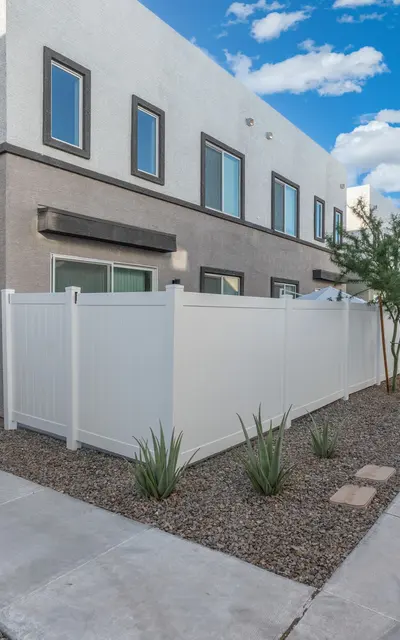 Modern Townhouse Exterior Exterior view of a modern townhouse with a white fence and landscaped paths.