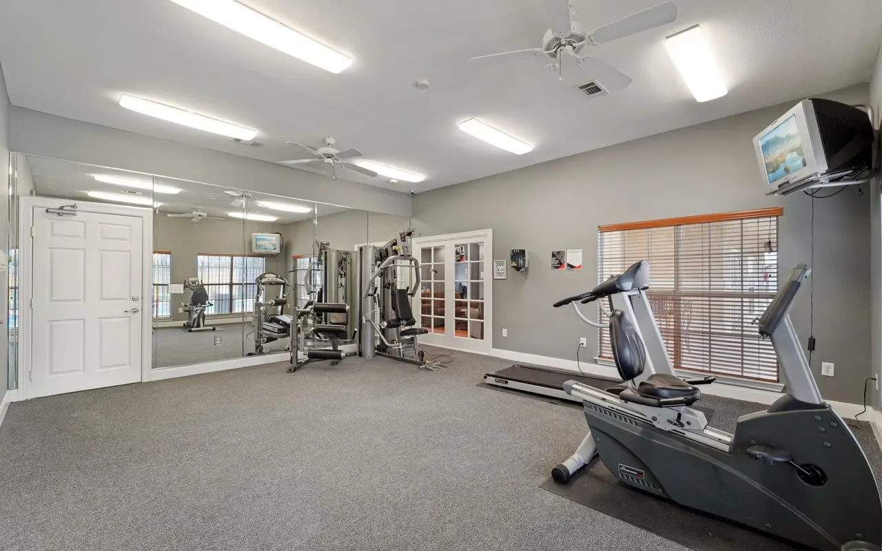 Interior of a gym with exercise equipment and mirrors