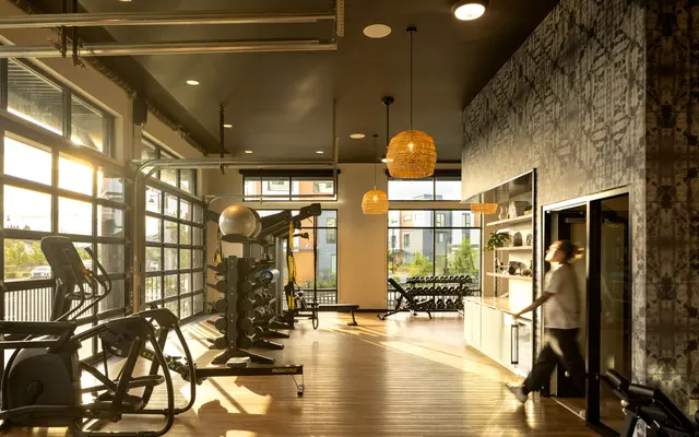 Modern Gym Interior Interior view of a modern gym with large windows, exercise equipment, and natural lighting.