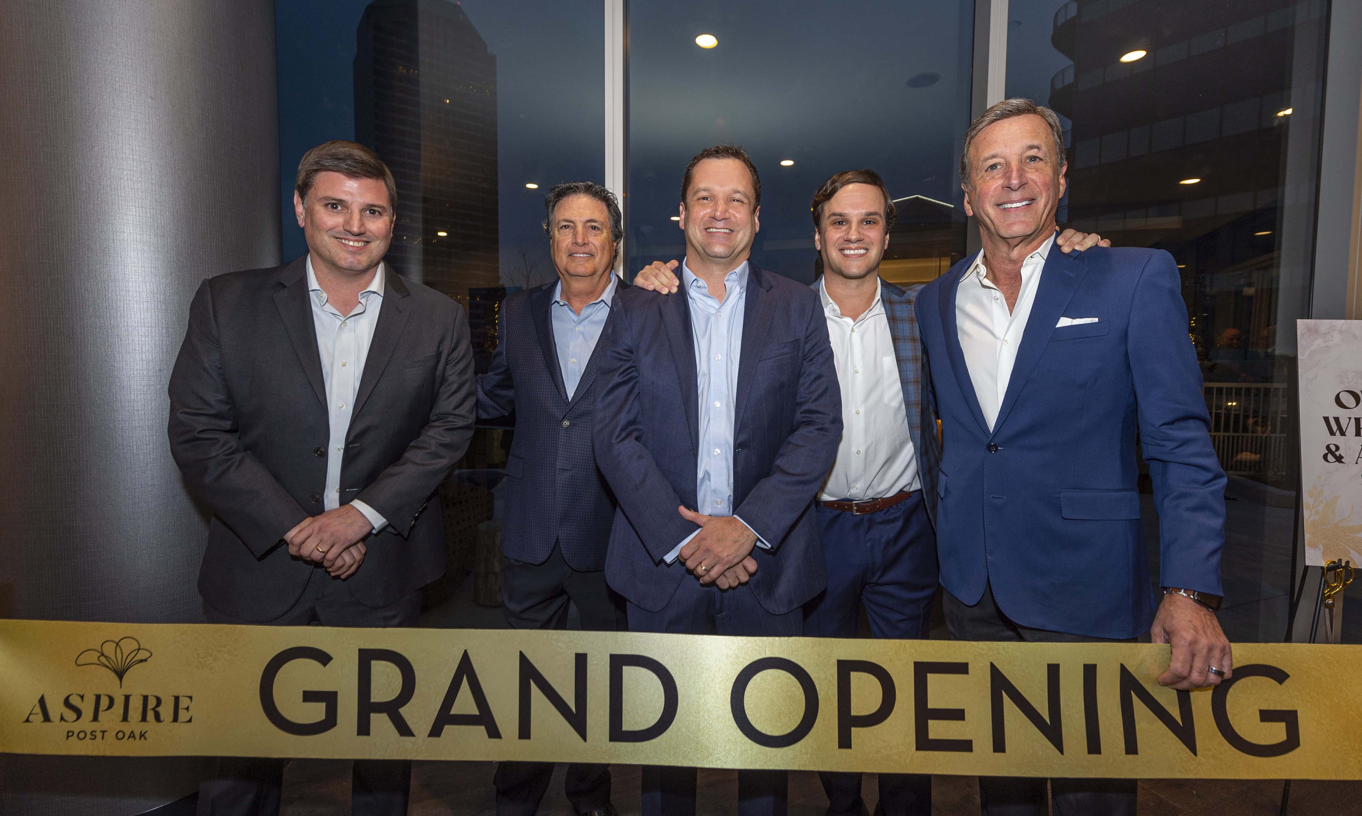 Grand Opening of Aspire Port Bar Group of five men posing in front of a large sign that reads 'Grand Opening' for Aspire Port Bar.