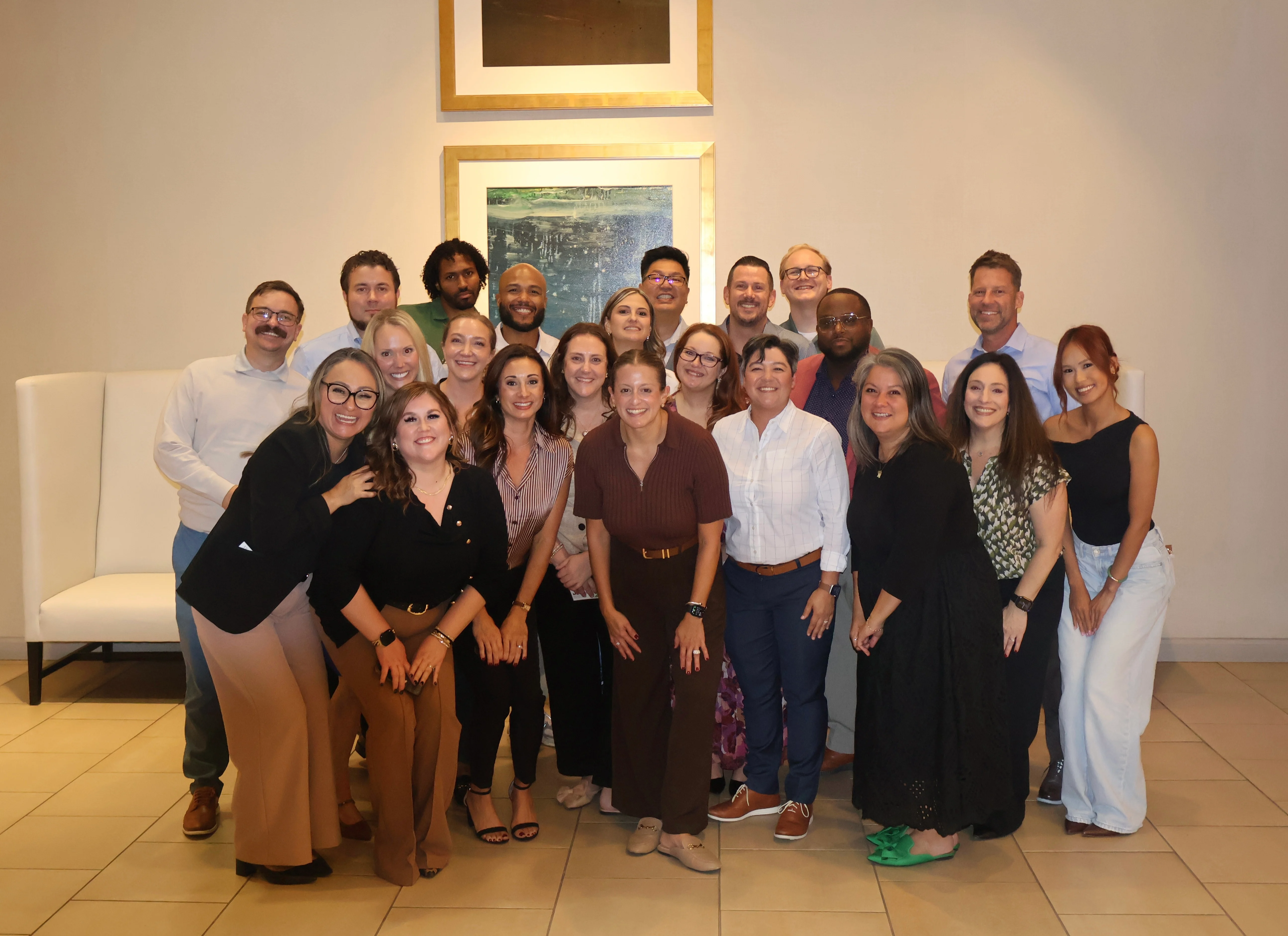 Team Gathering A large group of diverse people posing together in a well-lit indoor space, smiling for a group photo.