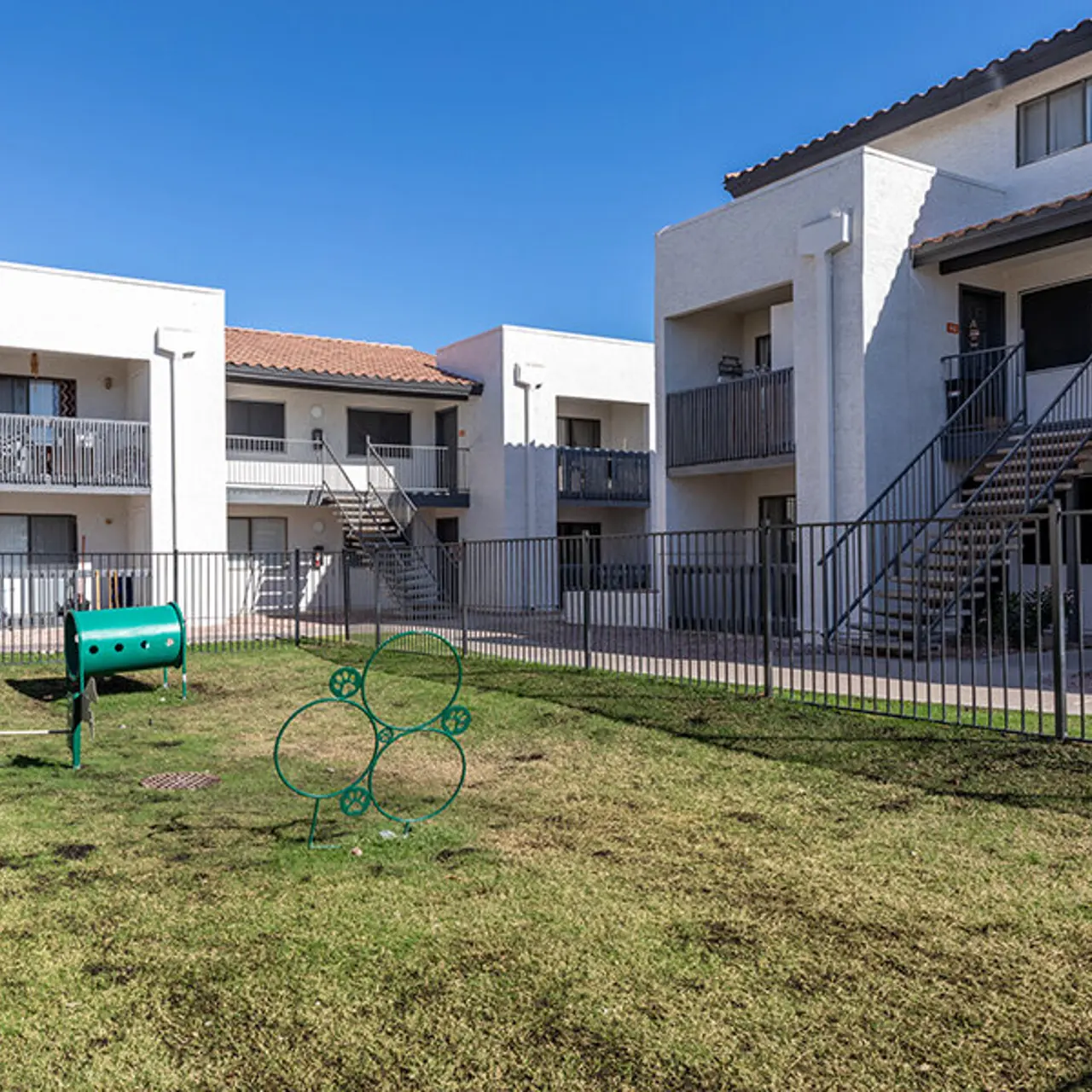 Exterior view of a small apartment complex with two buildings and a grassy courtyard.