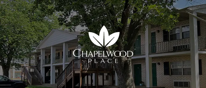 Chapelwood Place Residential Community Exterior view of a residential building with trees and a logo for Chapelwood Place in the center.