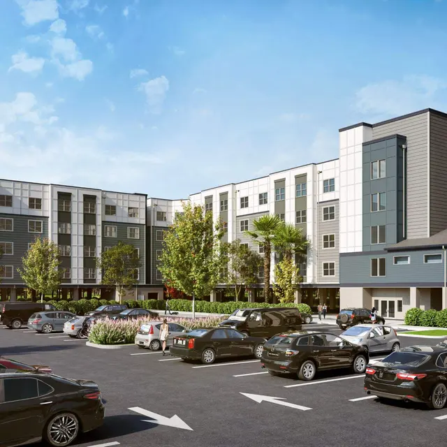 Modern Apartment Complex A modern apartment complex featuring multiple stories, surrounded by a parking lot filled with cars and landscaped with trees and shrubs.