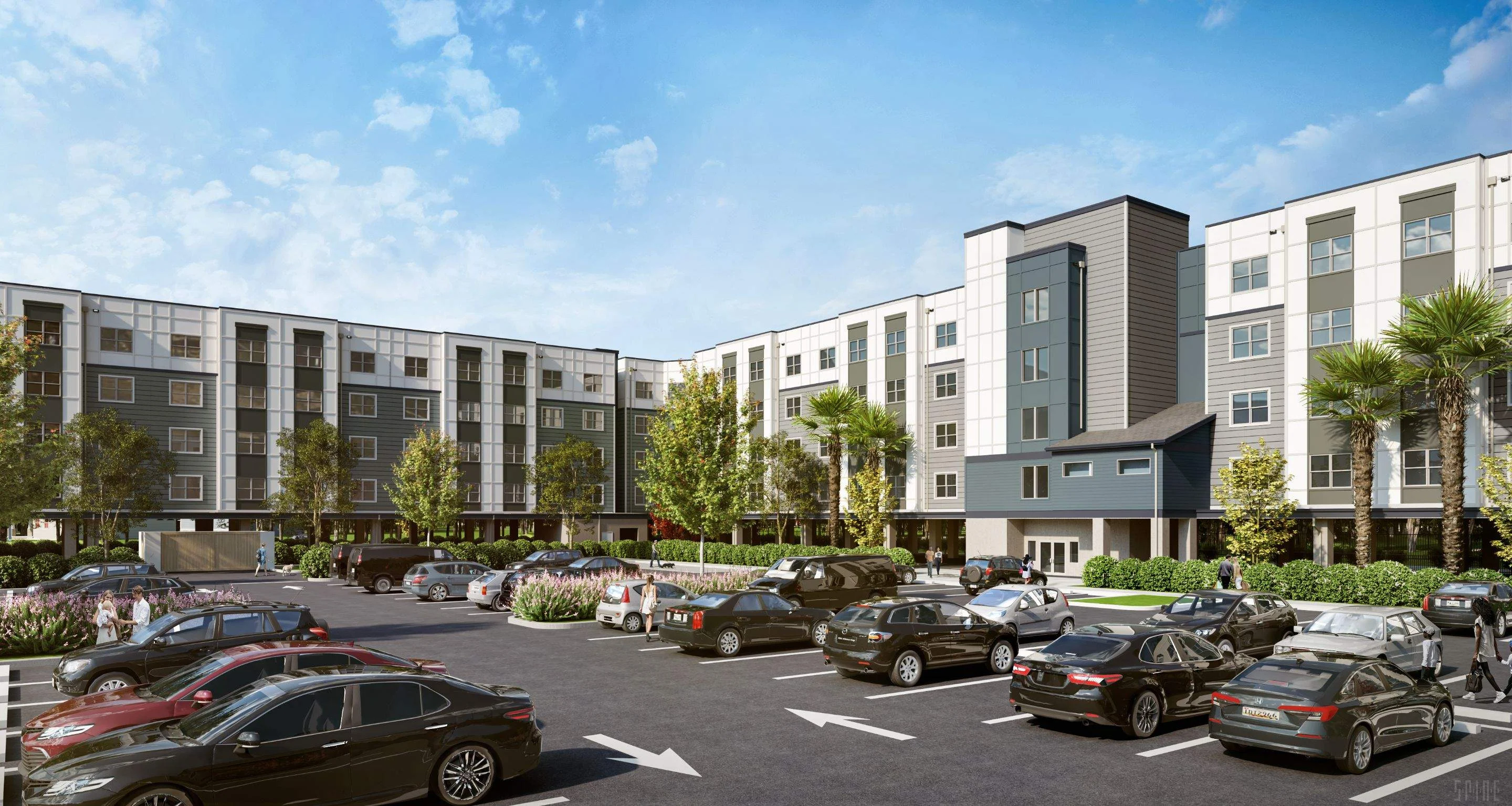 A modern apartment complex featuring multiple stories, surrounded by a parking lot filled with cars and landscaped with trees and shrubs.