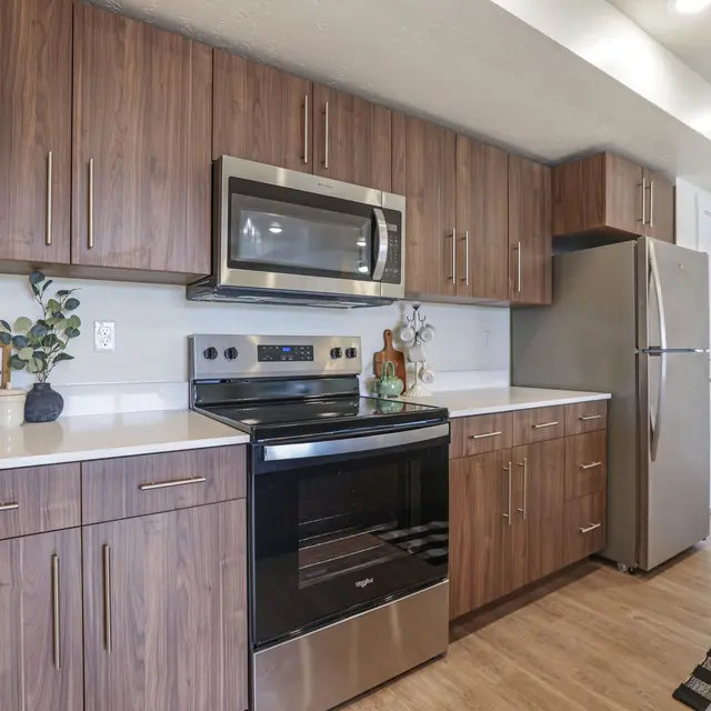 Modern Kitchen Design A modern kitchen featuring wooden cabinets, stainless steel appliances, and a neutral color palette. There is a sign that says 'yum.'