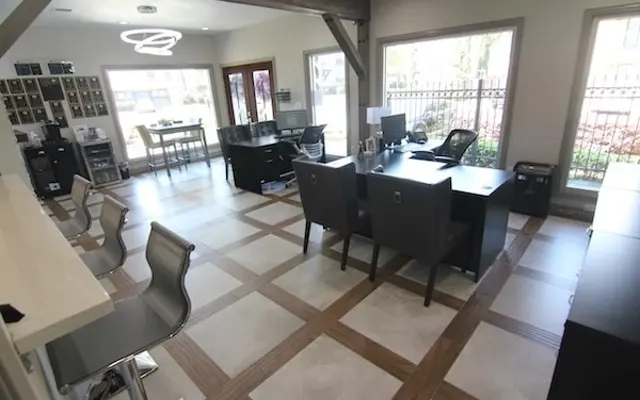 Modern Office Space Design A spacious modern office featuring multiple desks, a reception area, and large windows allowing natural light to enter.