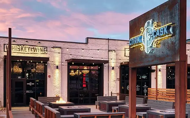 Cork & Cask Outdoor seating area in front of a venue labeled 'Whiskey & Wine' and 'Cork & Cask.'