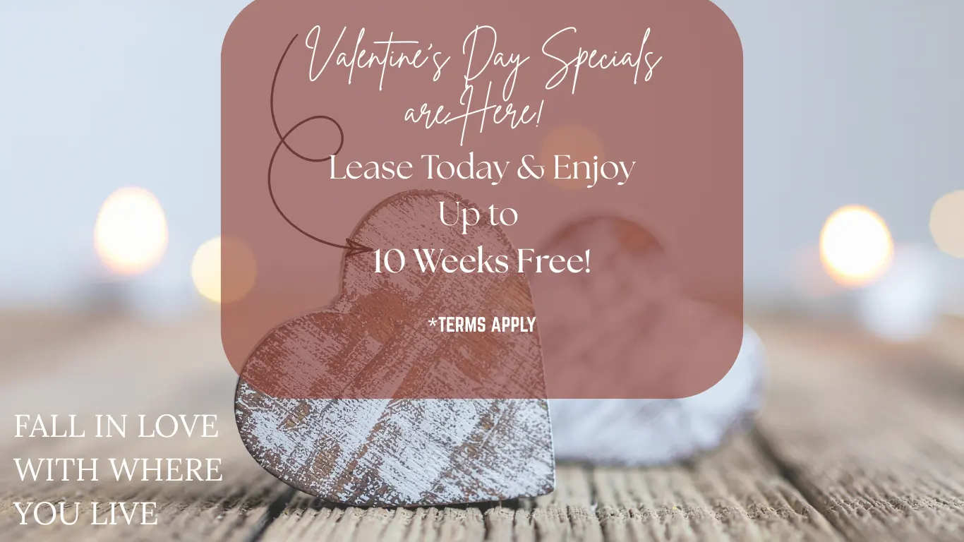 Promotional image for Valentine's Day leasing specials featuring wooden heart decorations on a rustic surface with soft lighting.