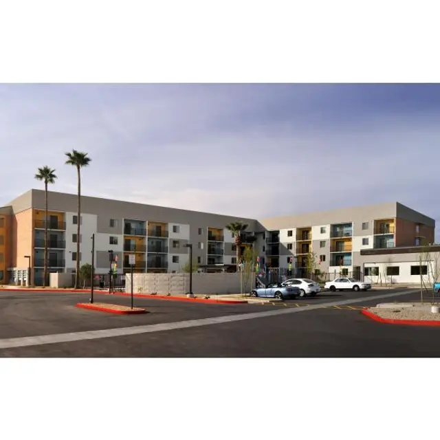 Modern Hotel Exterior A modern hotel building with a multi-story structure, palm trees in the foreground, and a parking lot visible. The building features a combination of beige and brown exterior with balconies.