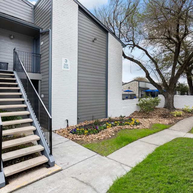 Apartment Exterior with Stairs Exterior view of an apartment building featuring stairs, landscaped garden, and walkways.