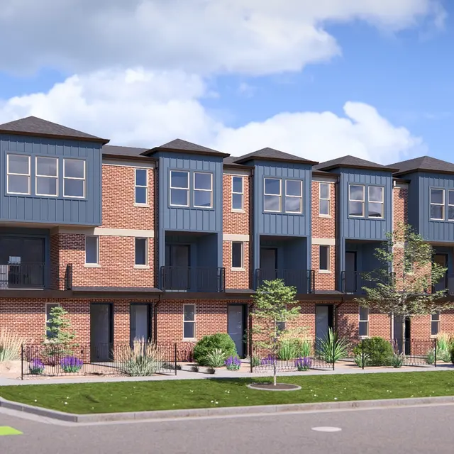 A modern row of townhouses featuring brick exteriors and dark blue accents, surrounded by greenery and a clear blue sky.