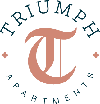 Logo for Triumph Apartments featuring the name 'Triumph' in large letters and a stylized letter 'T' enclosed in a circular design with stars on either side.