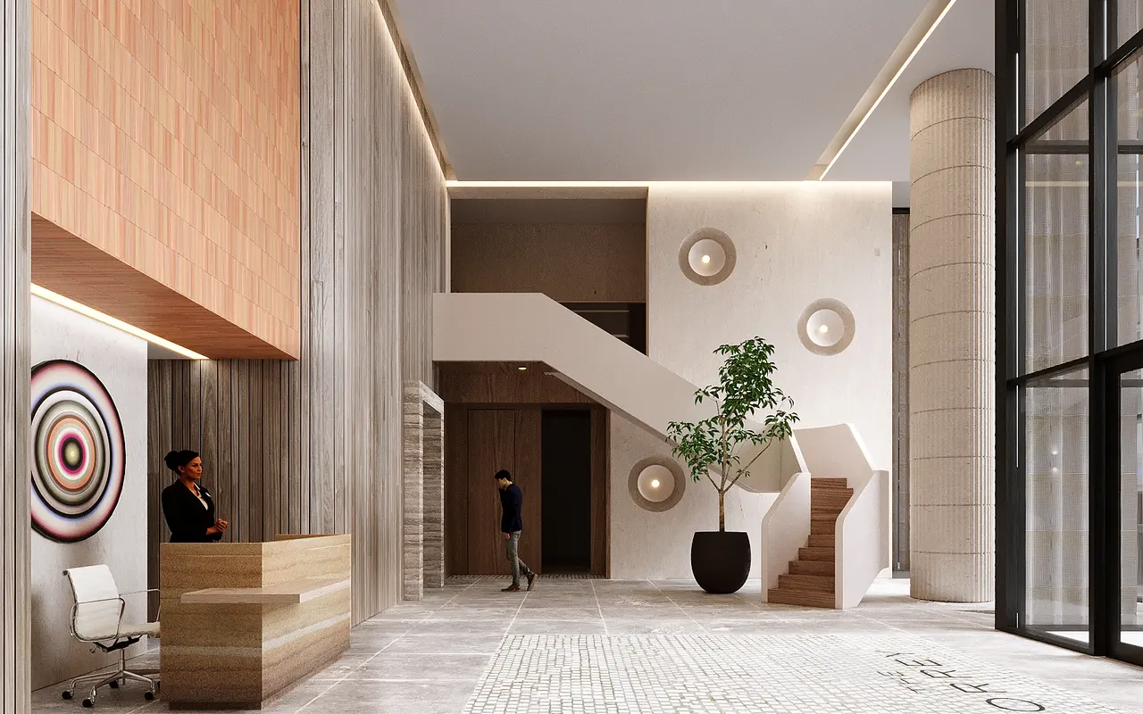 A modern lobby featuring a reception desk, a potted plant, and artistic wall decor. There are staircases in the background and a person walking towards the entrance.