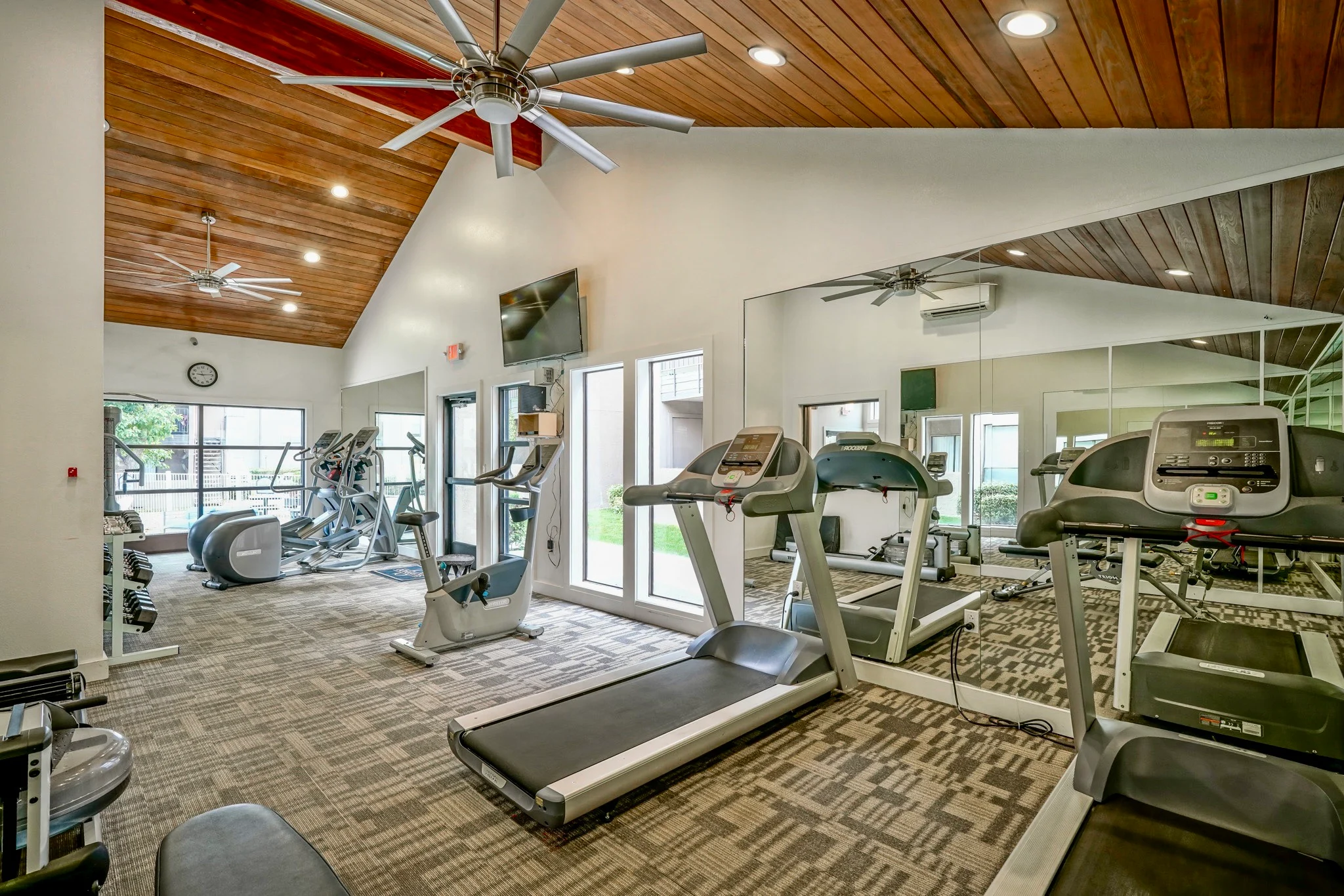 Spacious Gym Interior Interior view of a gym featuring treadmills and exercise equipment under a wooden ceiling.