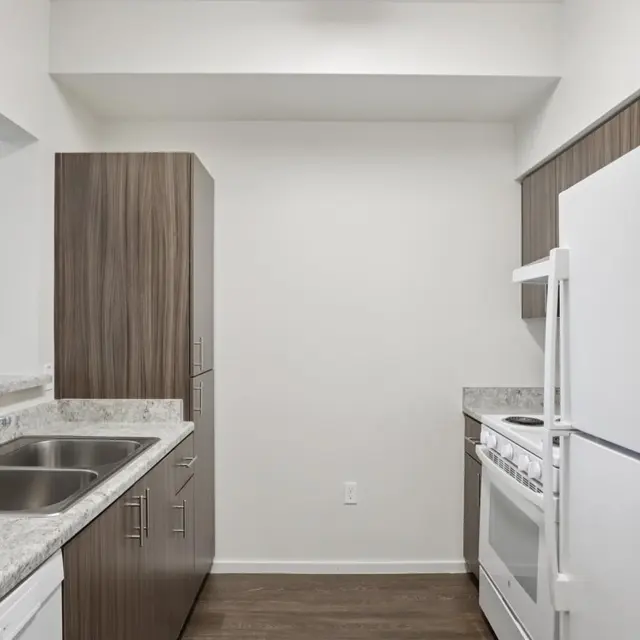 Modern Kitchen Design A modern kitchen featuring wood cabinetry, a white refrigerator, a stove, and a microwave.