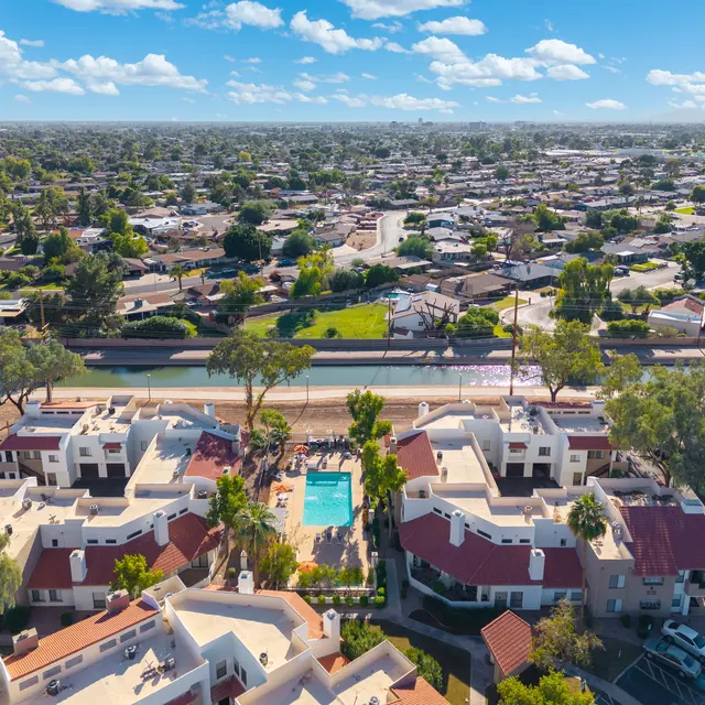 Aerial view of a residential area featuring a swimming pool and surrounding homes.