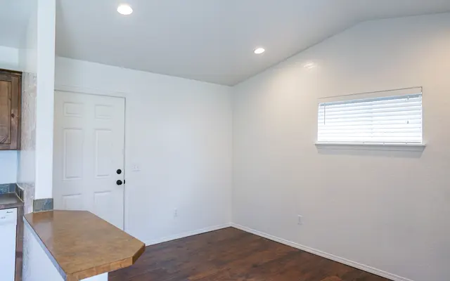 Bright and Airy Living Room Interior view of a living room featuring light-colored walls, a wooden floor, and a small window.