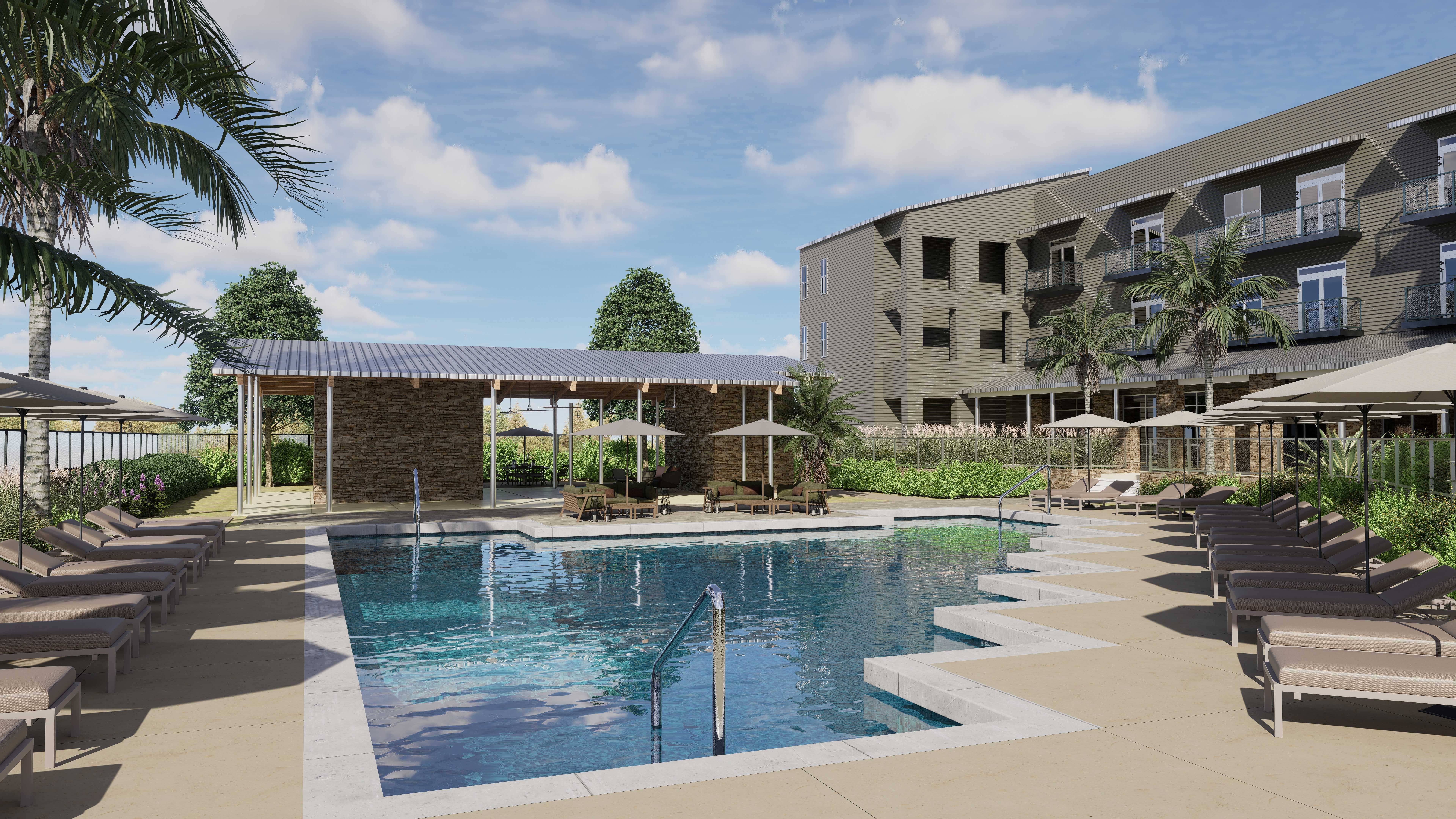 A modern swimming pool area surrounded by lounge chairs, with a pergola, landscaping, and a multi-story building in the background.