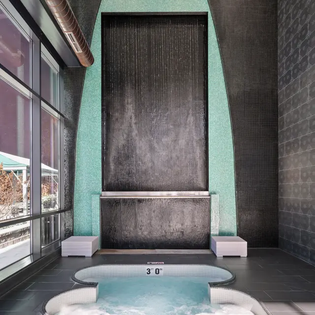 Contemporary spa area featuring a waterfall and a hot tub.