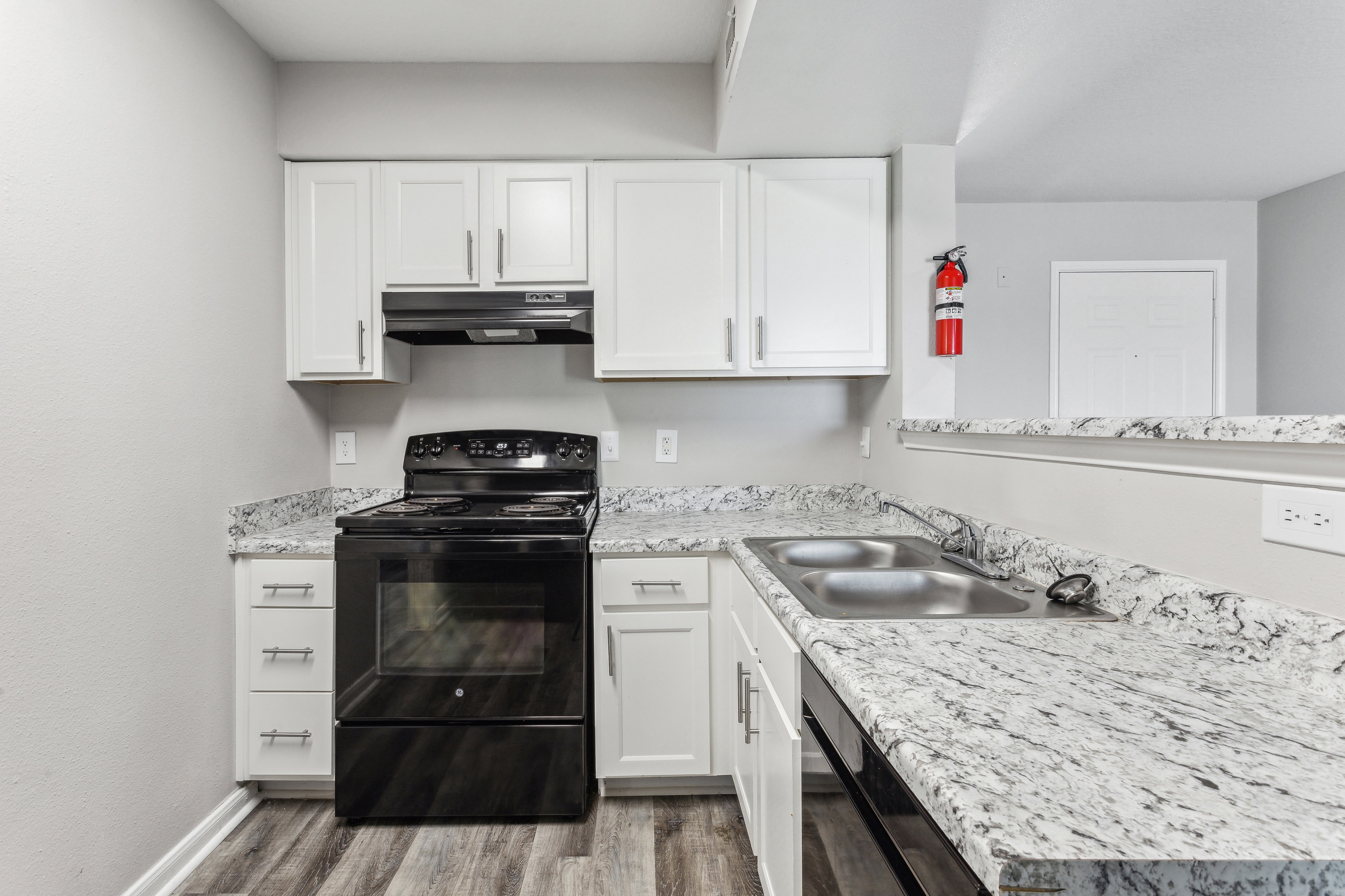 Modern Kitchen Interior A modern kitchen featuring white cabinets, black appliances, and a granite countertop.