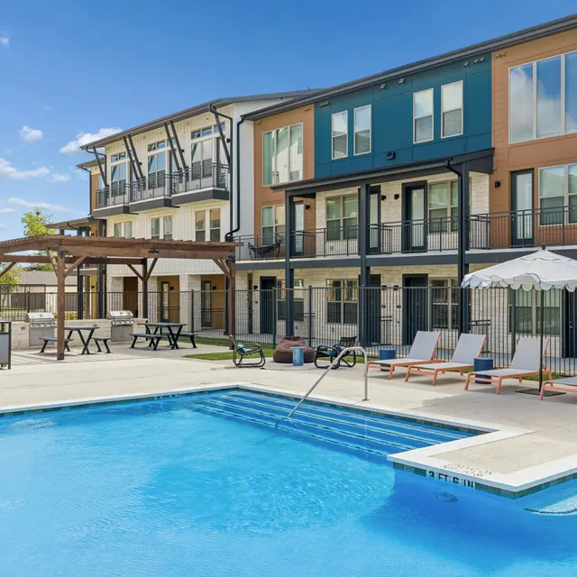 Modern Apartment Pool Area Outdoor pool area with seating and apartment buildings in the background.