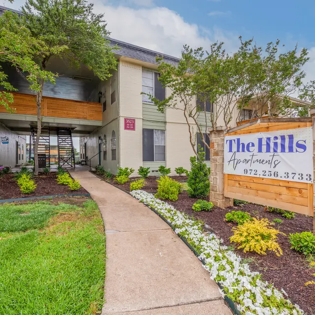 The Hills - Exterior view of The Hills Apartments featuring landscaped lawn and a welcoming entrance.