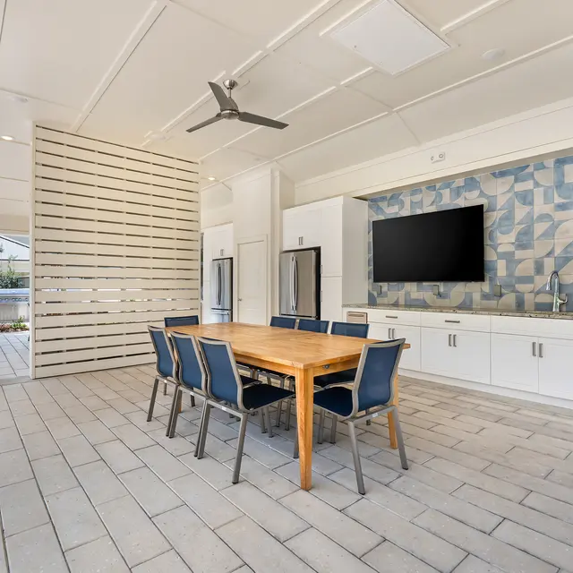 Stylish Indoor Dining Area A spacious indoor dining area featuring a wooden table with chairs and a decorative wall.