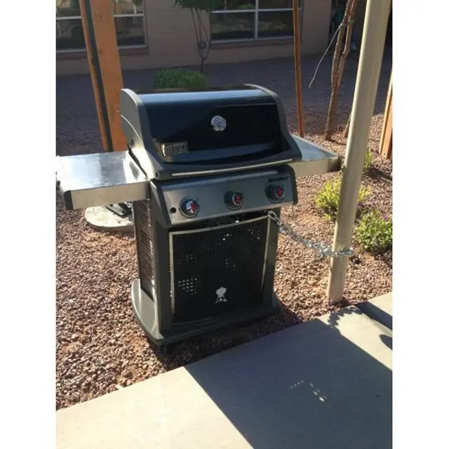 Outdoor Gas Grill An outdoor gas grill situated on a patio surrounded by gravel and plants.