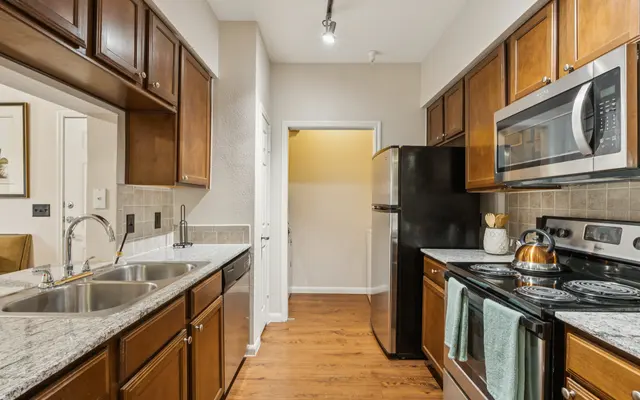 Modern Kitchen Design A modern kitchen featuring dark wood cabinetry, stainless steel appliances, and a granite countertop.