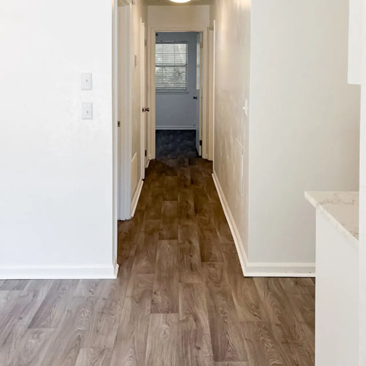 Long hallway in a modern interior with light-colored walls and wooden flooring