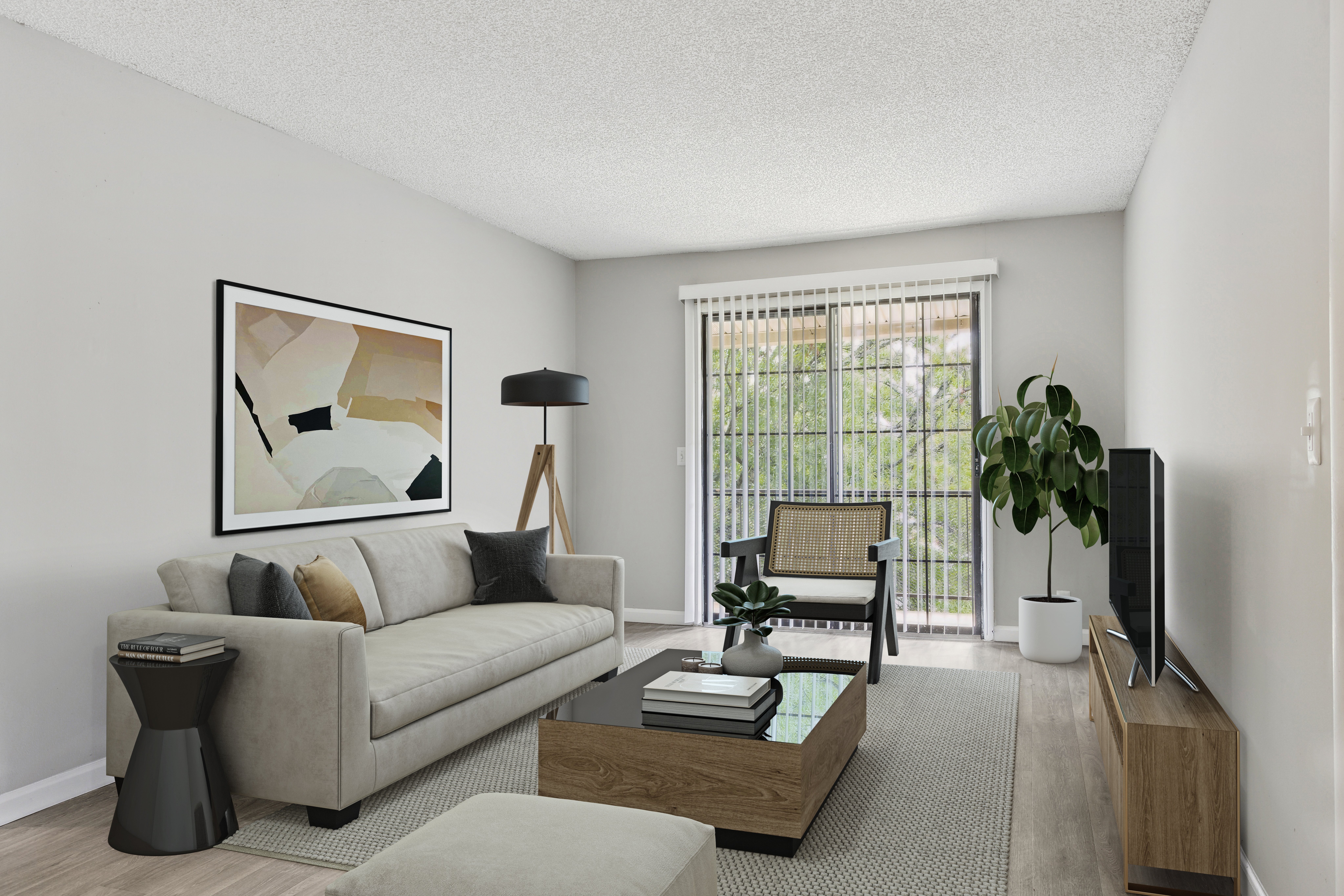 A modern living room featuring a light gray sofa with decorative pillows, a dark wood coffee table, and a small black side table. There is a floor lamp and an abstract artwork on the wall. Large windows with blinds allow natural light, and a potted plant is in the corner, adding a touch of greenery to the space.