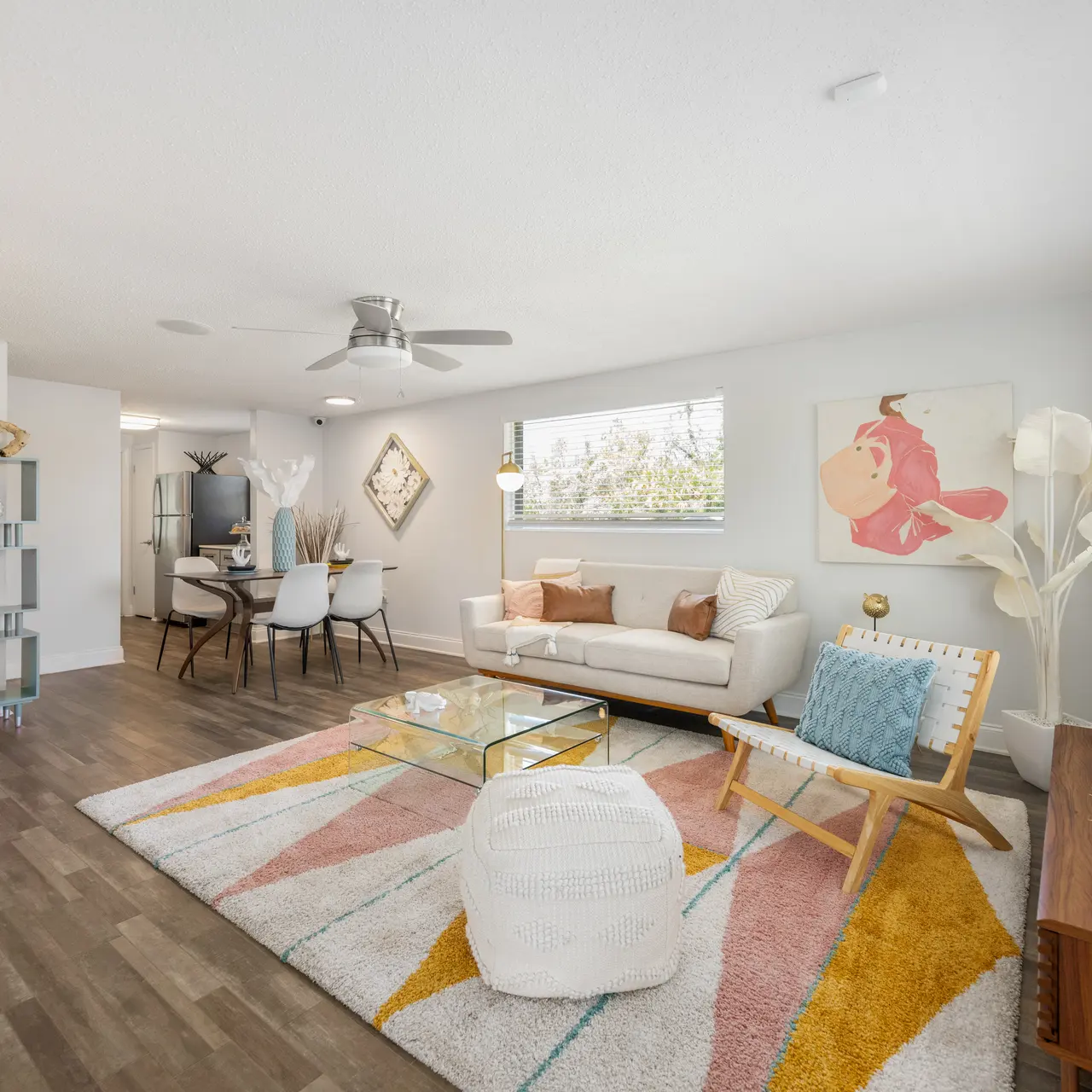 Modern living room featuring light-colored walls, a comfortable white sofa, and stylish decor elements including a colorful rug and artwork.