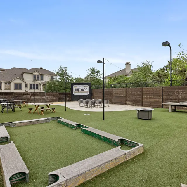 A recreational area with artificial grass, seating, and games.