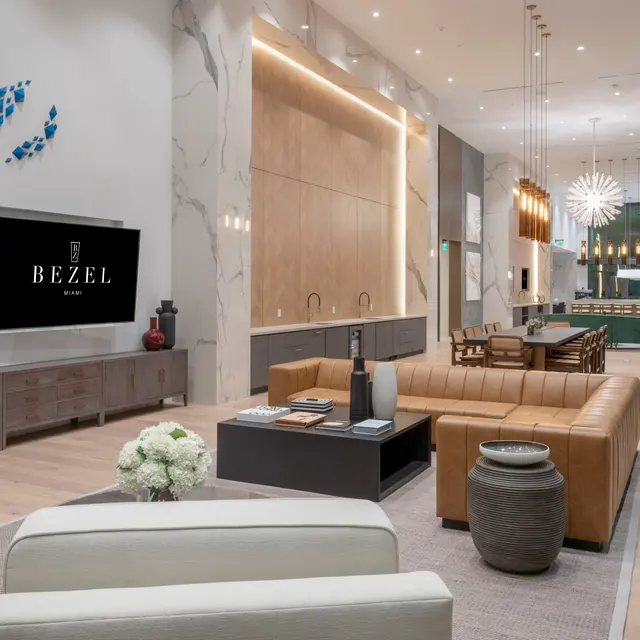 A modern lobby with stylish furniture and contemporary decor, featuring a large TV on the wall and a decorative wall installation.