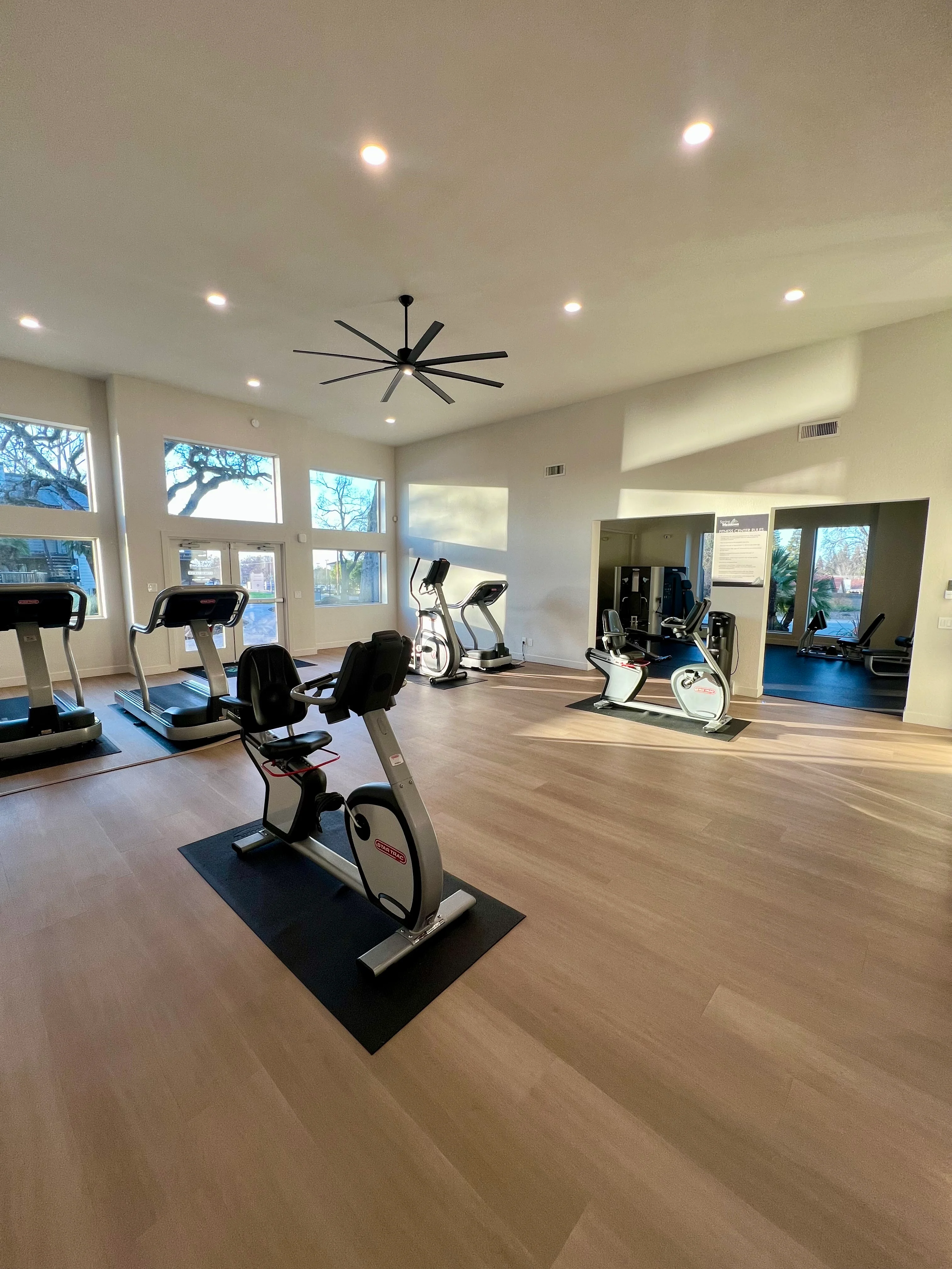 Bright and spacious gym featuring cardio equipment and large windows.
