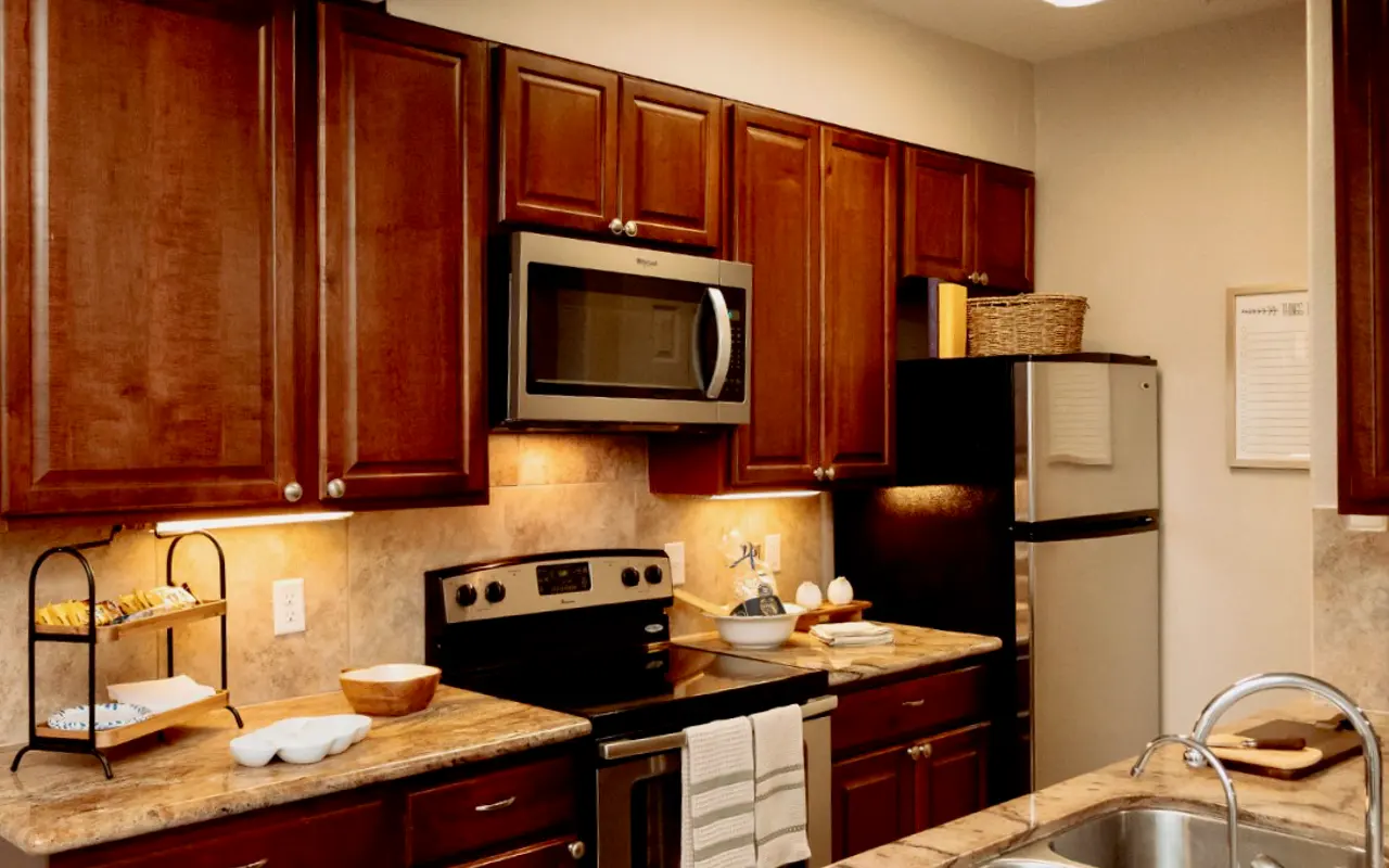 Modern Kitchen Design A modern kitchen featuring wooden cabinets, stainless steel appliances, and a minimalist countertop with decorative items.