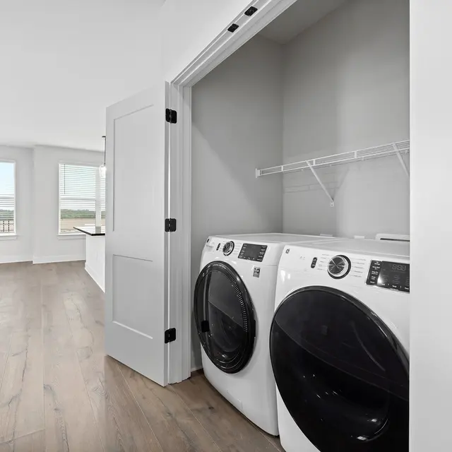 Modern Laundry Room A modern laundry room featuring two front-loading washing machines in a neutral-colored space with large windows.