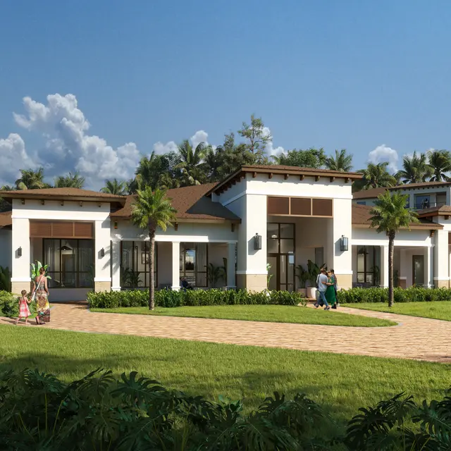 A modern residential building with a wide entrance and a landscaped front yard, featuring palm trees and a smooth pathway.