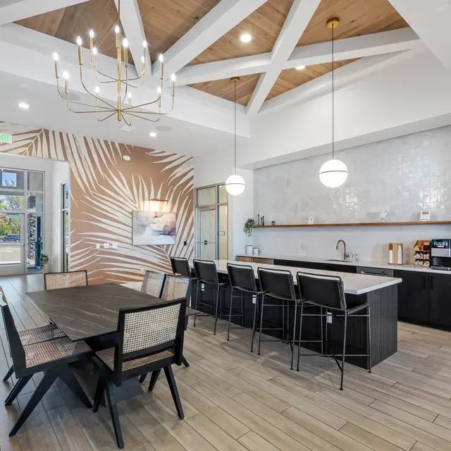 Modern Kitchen Interior A modern kitchen with a large dining table and bar seating. The ceiling features a crossbeam design. The walls are adorned with a decorative pattern, and there are pendant lights hanging above the bar area.