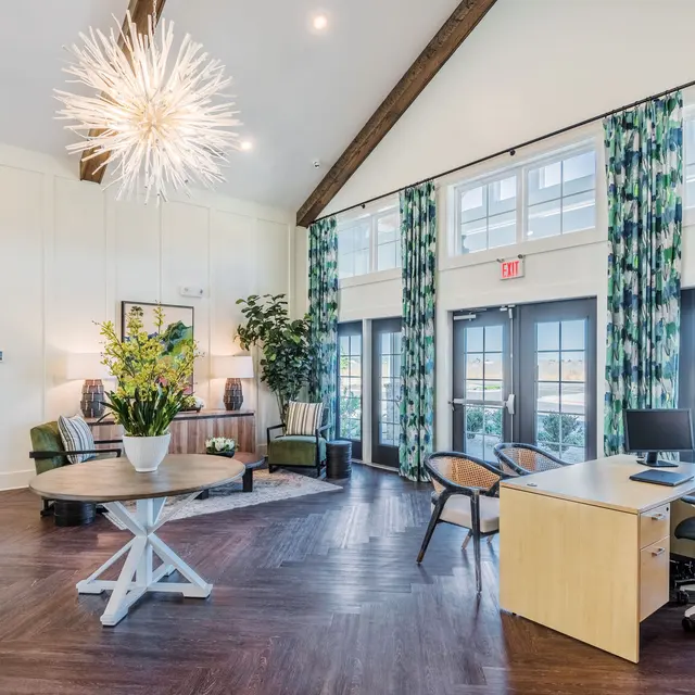 Modern Lounge Area Bright and inviting lounge area featuring modern decor, large windows, and a stylish chandelier.