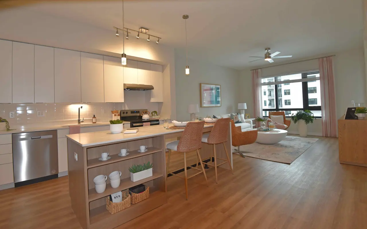 A modern and spacious apartment interior showcasing an open kitchen and living area.