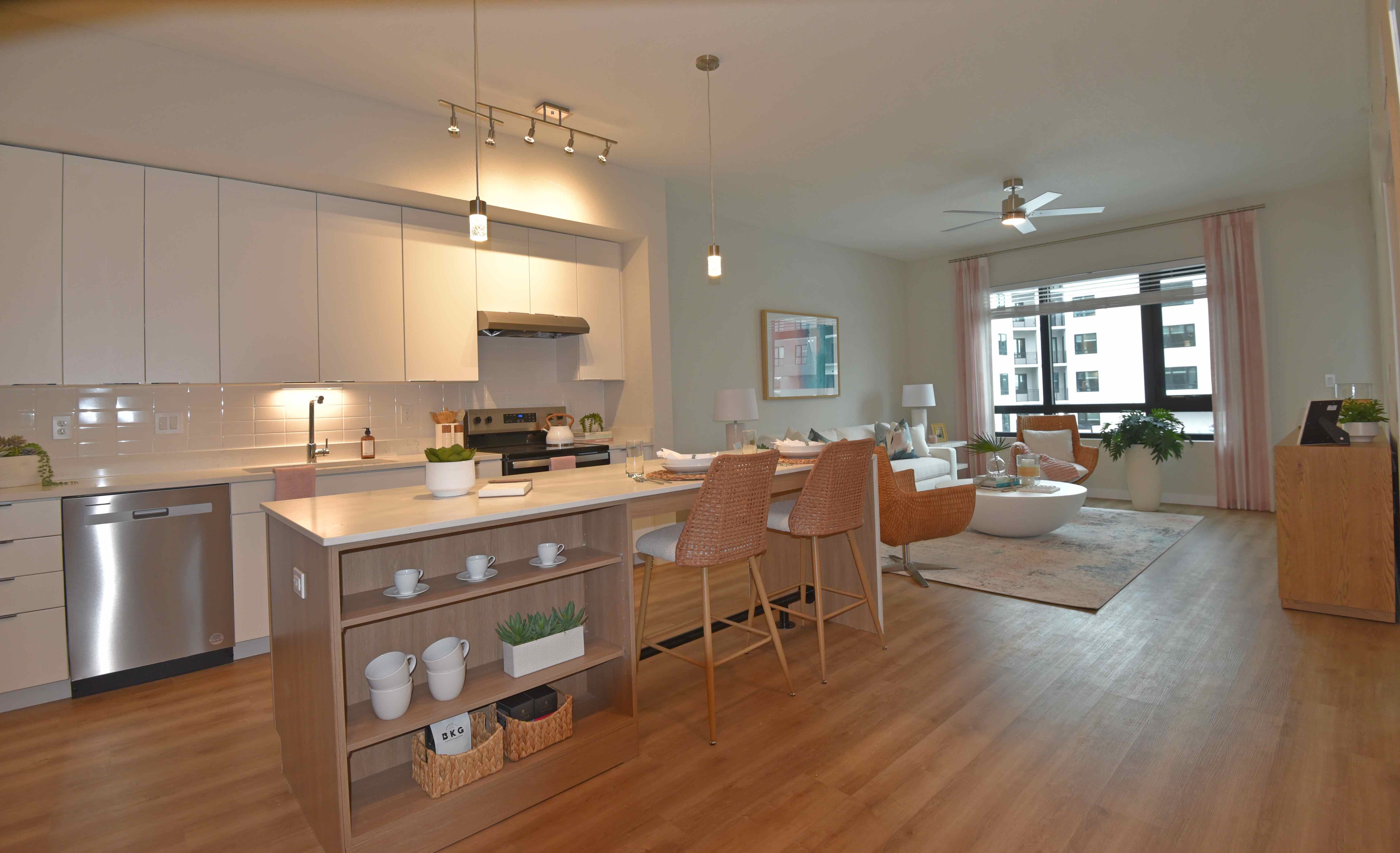 A modern and spacious apartment interior showcasing an open kitchen and living area.