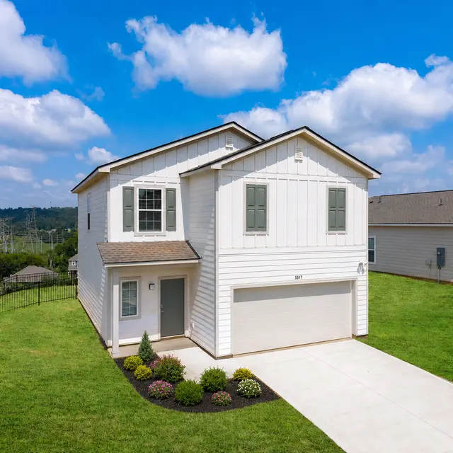 A modern two-story house with white siding and a well-manicured lawn